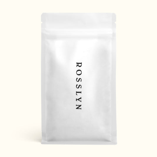 A sealed white bag of Rosslyn branded coffee beans.